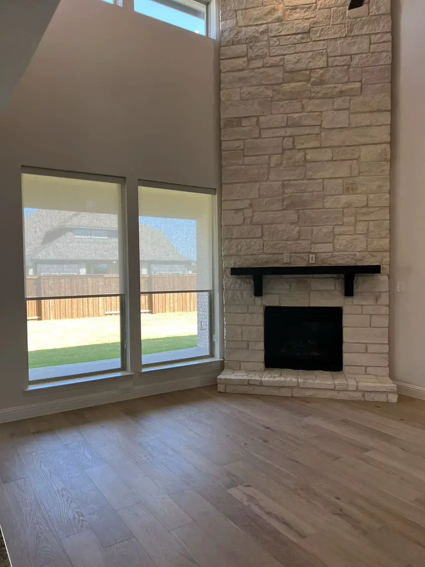 Solar roller shades beside a stone fireplace